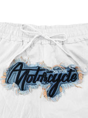 White drawstring sweatpants with a distressed denim patch featuring black embroidered "Motorcycle" text.