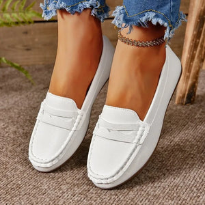 White metallic loafer flats with subtle stitching and a strap detail.