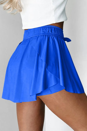 Blue flared skort with tie waist and elastic waistband.