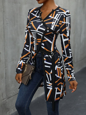 Black geometric print asymmetric blouse with decorative buttons and a harness detail.