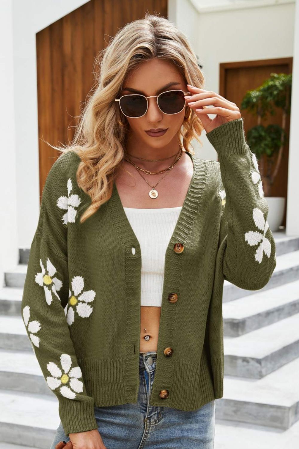 Green acrylic button-down cardigan with white daisy embroidery and a V-neck.