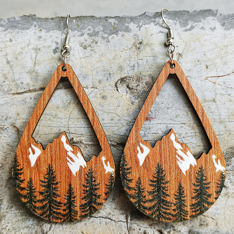 Teardrop silhouette earrings with mountain and pine tree scene, wood grain detail