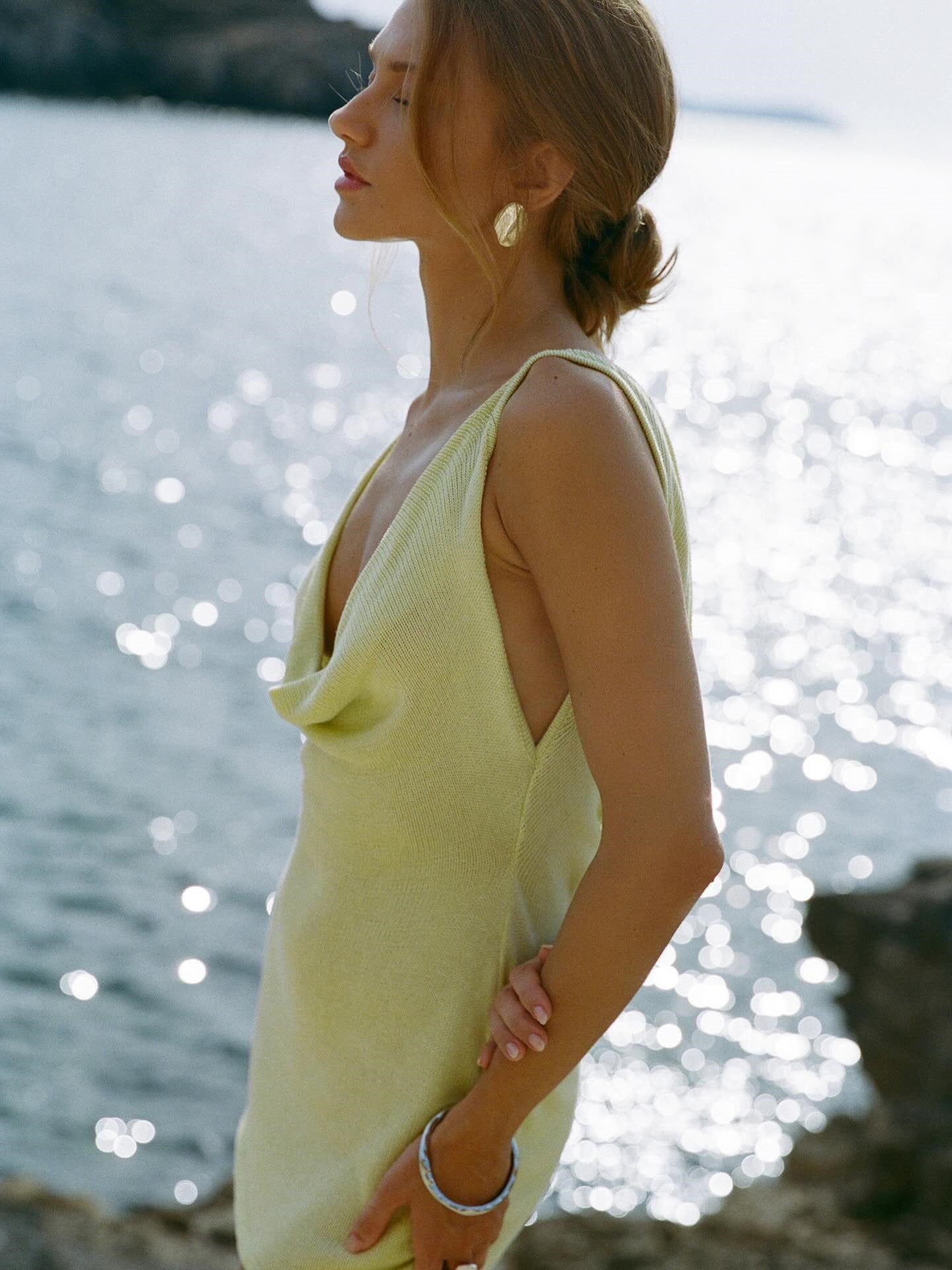 Yellow cowl neck mini dress with drawstring detail and open sides.