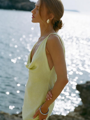 Yellow cowl neck mini dress with drawstring detail and open sides.