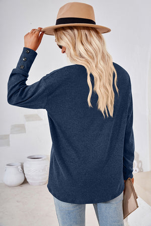 Dusty Blue slouch v-neck top with button cuffs and long sleeves.