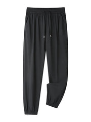 Black drawstring joggers with elastic cuffs and a subtle embossed logo detail.