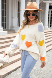 Ivory fluffy knit sweater with multicolor heart pattern, crew neck, long sleeves.