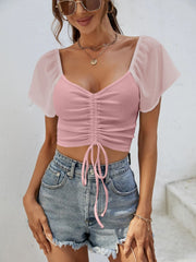 Pink ribbed crop top with chiffon sleeves and adjustable drawstring detail.