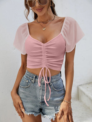 Pink ribbed crop top with chiffon sleeves and adjustable drawstring detail.