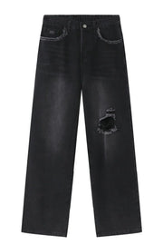 Distressed dark wide-leg jeans with raw hem and ripped knee detail