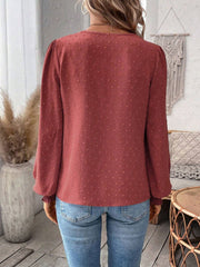 Rust embroidered yoke blouse with puff sleeves and textured fabric.