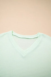 Light green waffle knit V-neck maternity t-shirt with relaxed fit.