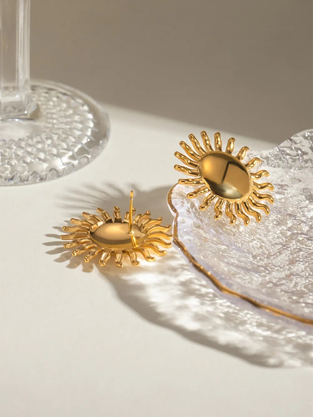 Gold sun stud earrings with sculpted rays, 18K gold-plated.