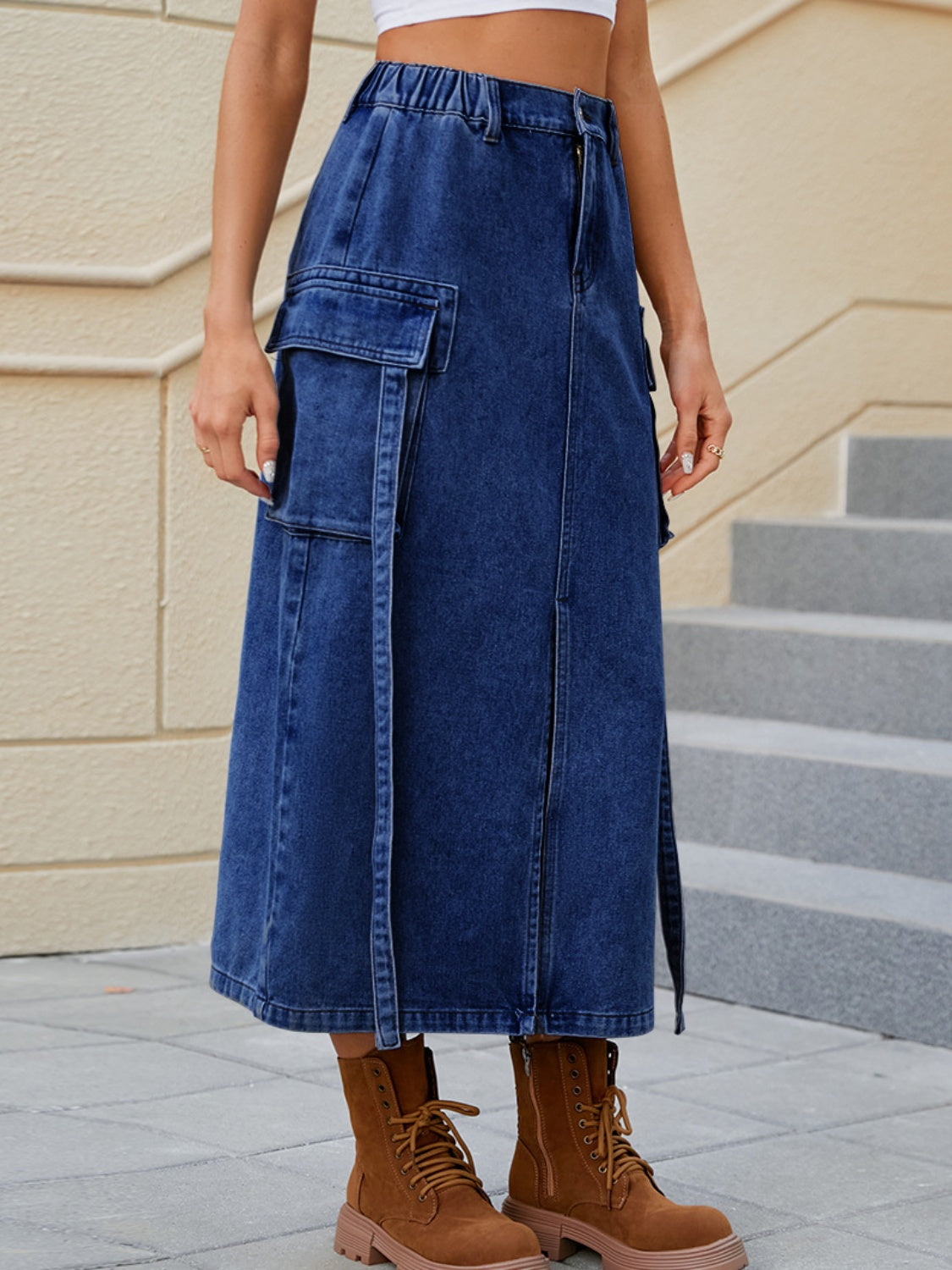 Dark blue denim midi skirt with cargo pockets and a front slit.