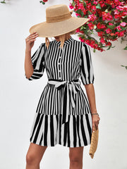 Black and white striped shirred waist dress with tie belt and tiered skirt.