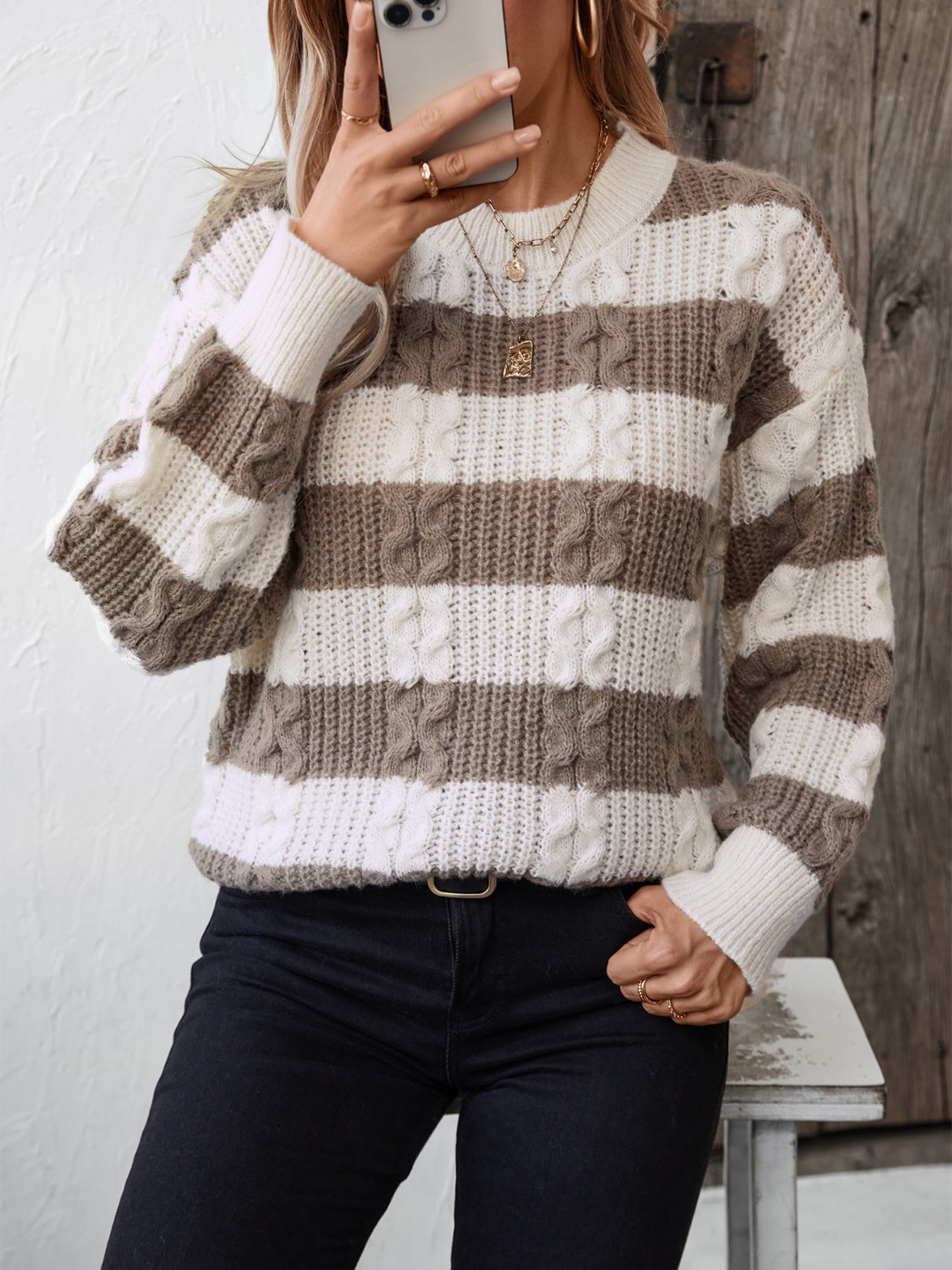 Cable knit stripe crewneck sweater in taupe and white with crew neckline and long sleeves.