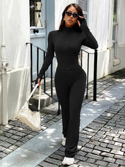 Black zippered activewear set with thumbhole sleeves and flared pants.