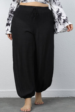 Black textured balloon-leg drawstring trousers with elastic cuffs