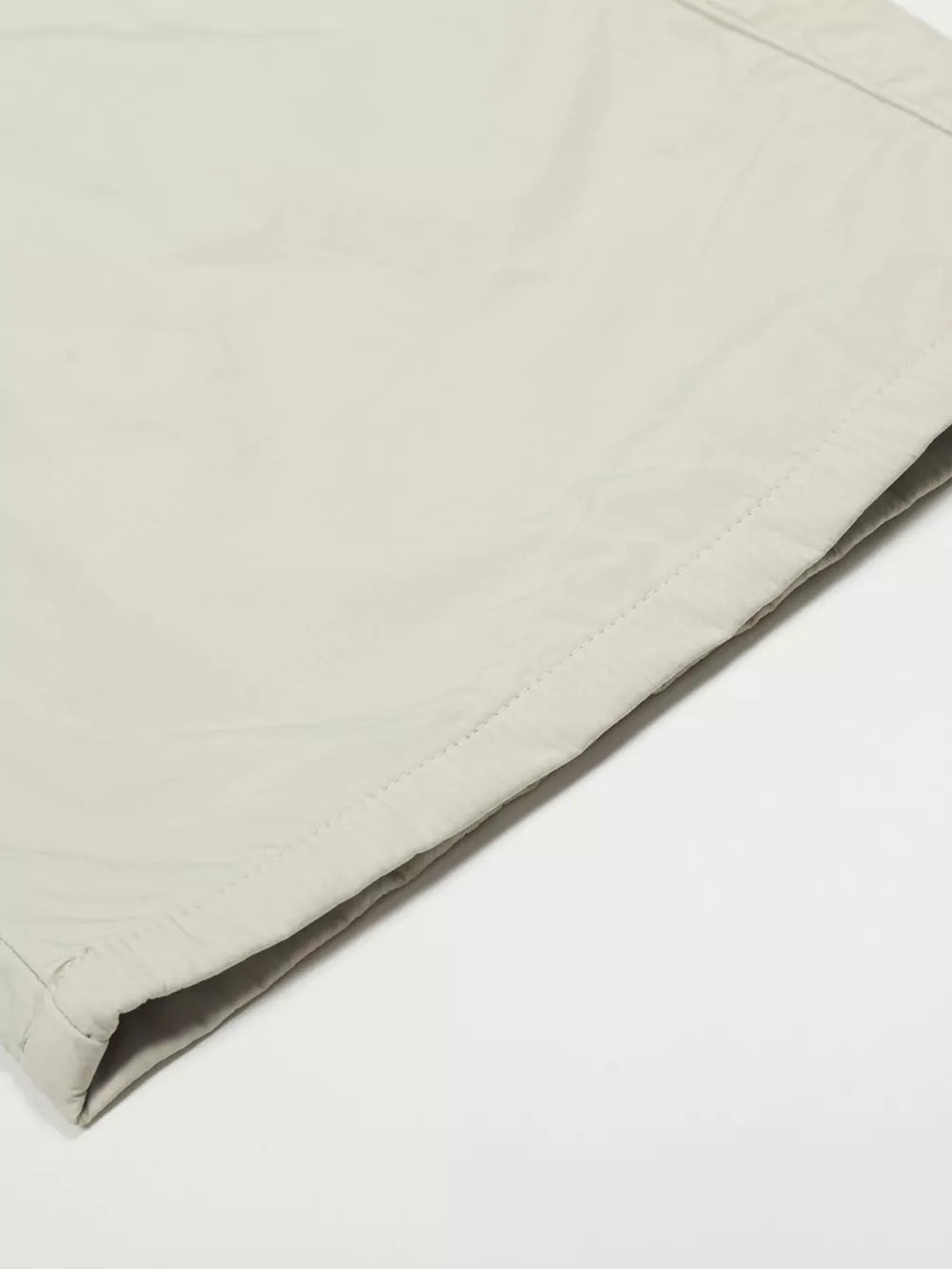 Men's light gray wide-leg sweatpants detail showing crinkled fabric and stitching.