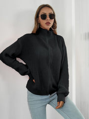 Black ribbed knit zip-up sweater with mock neck and long sleeves.