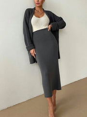 Dark gray ribbed knit midi skirt and matching open cardigan set with a cream tank top.