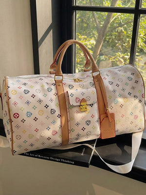 Vibrant monogram leather travel bag with tan trim and gold hardware.