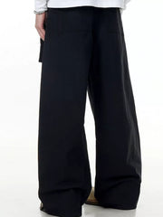 Black wide-legged cargo pants with buttoned pockets and a relaxed fit.