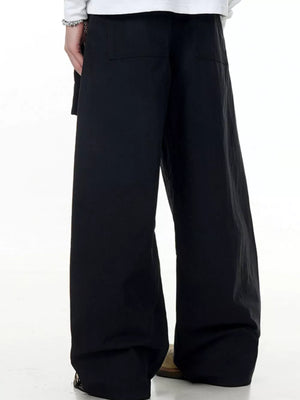 Black wide-legged cargo pants with buttoned pockets and a relaxed fit.