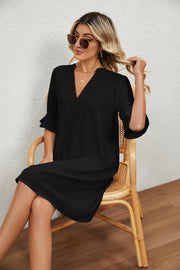 Black V-neck shift dress with flutter sleeves and a relaxed fit.