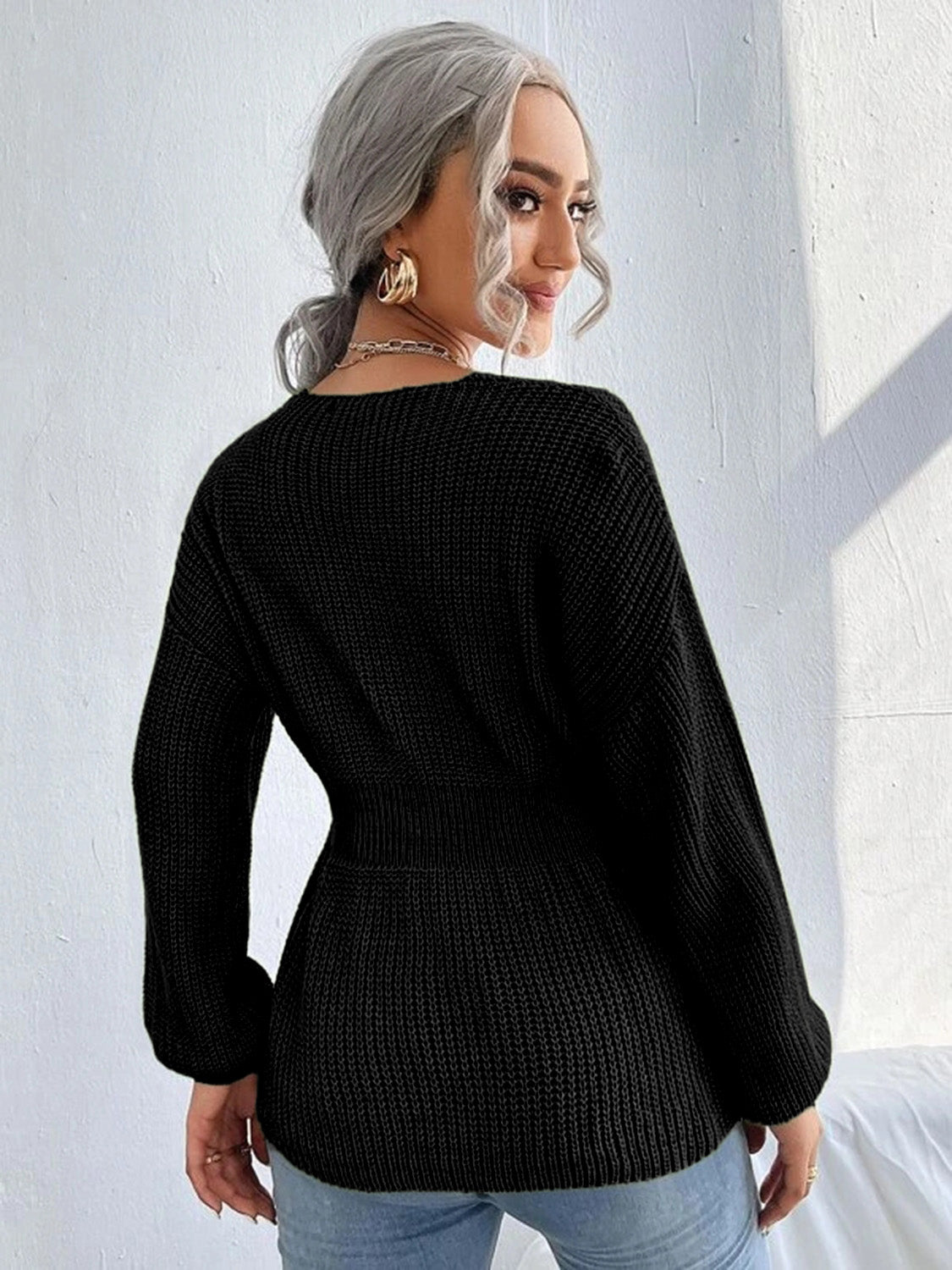 Black peplum knit sweater with scallop neckline and long sleeves.