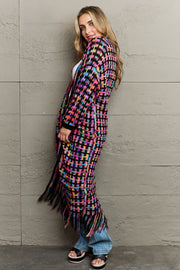 Crocheted maxi cardigan with fringe in multi-color plaid pattern and acrylic material.