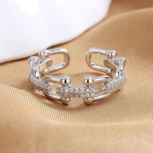 Open chain-link ring with pave zircon details in white gold color.