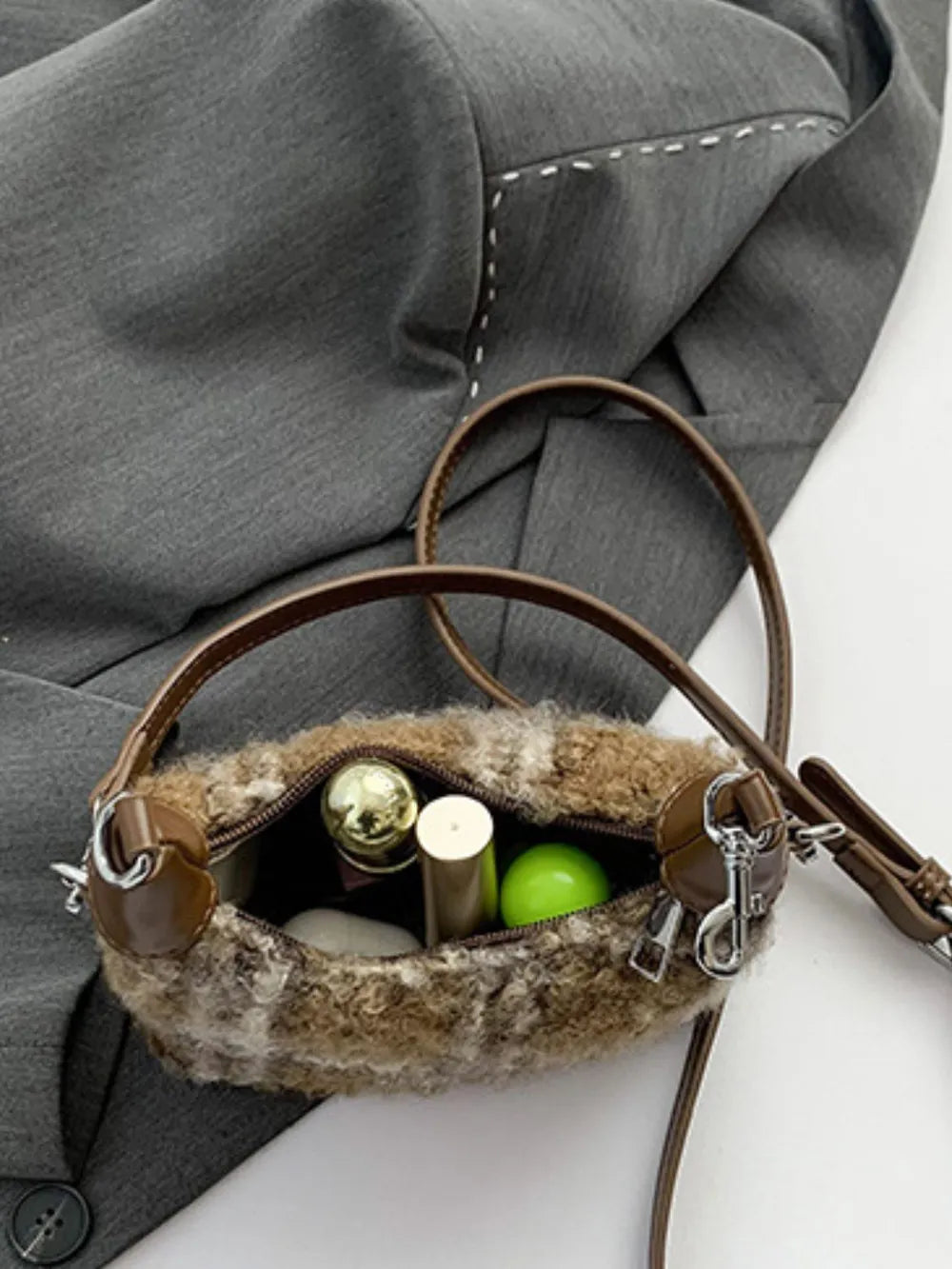 Shearling check mini shoulder bag with brown trim and strap, open to show makeup.