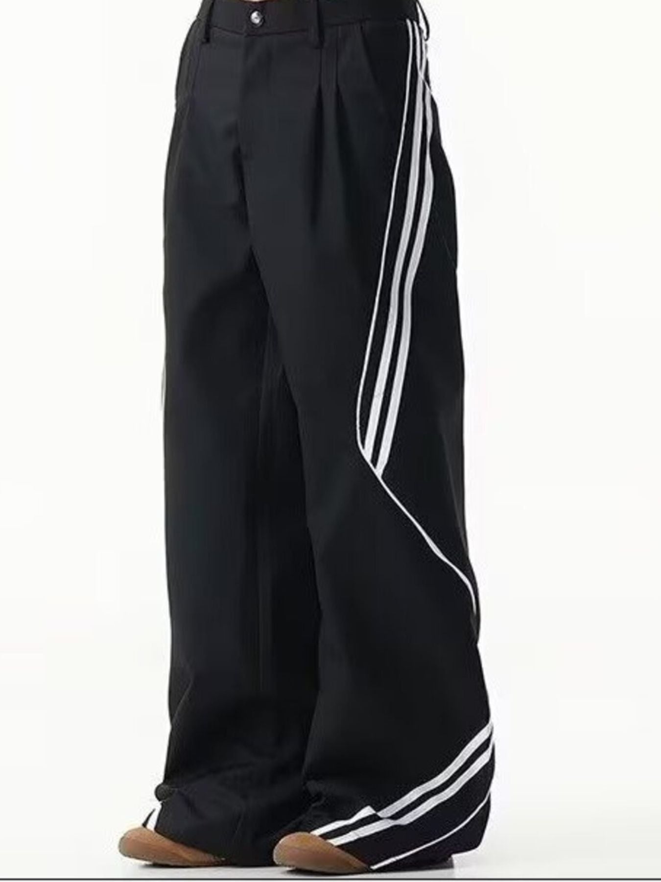Men's black wide leg track pants with white side stripes and pleats.