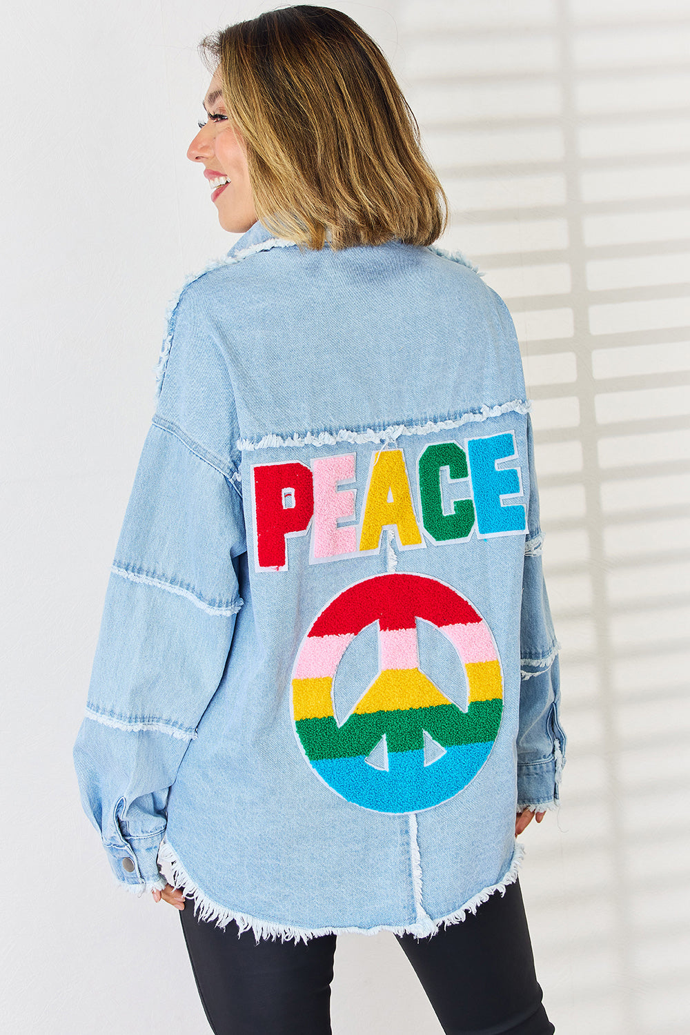 Light wash denim overshirt with colorful embroidered PEACE lettering and peace sign.