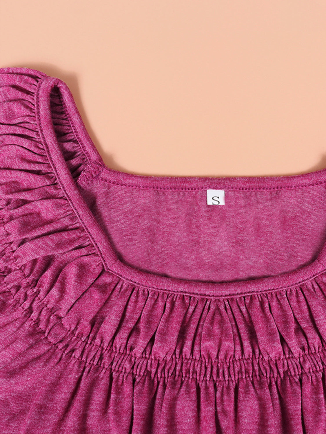 Off-shoulder ruffled sleeve top in hot pink with a square neckline.