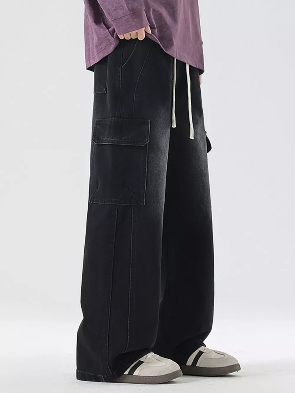 Black oversized cargo jeans with drawstring waist and large side pockets.