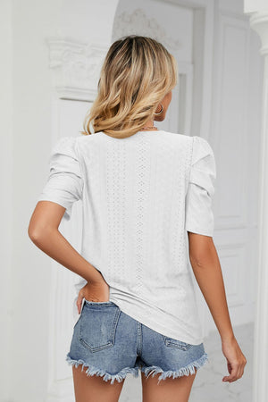White perforated sleeve volume top with puff sleeves and a textured pattern.
