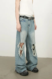 Distressed wide-leg denim jeans in medium wash with fraying and ripped details.