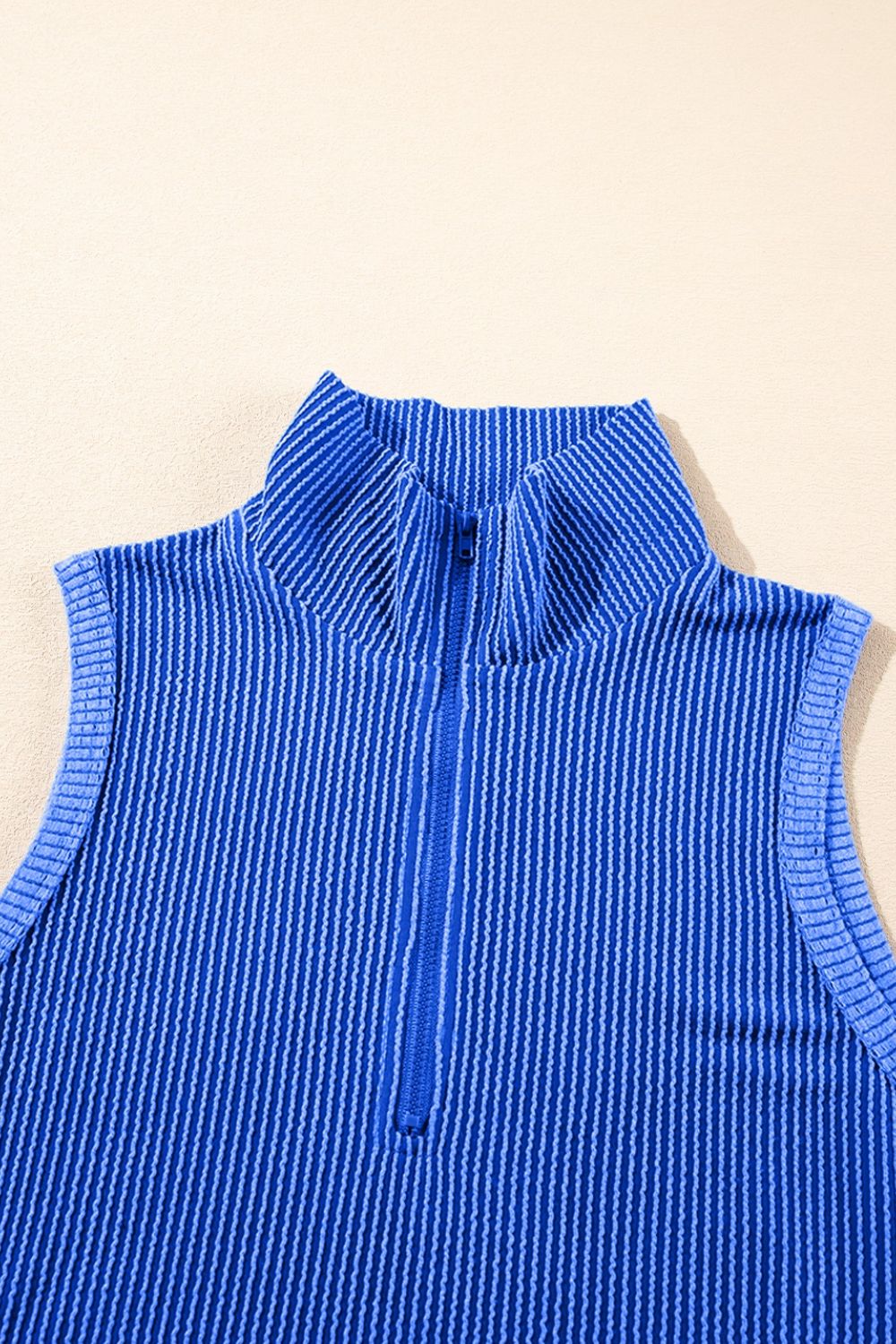 Royal blue ribbed polo top with a quarter zip and vertical stripe texture.