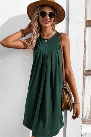 Forest green sleeveless trapeze dress with pleated yoke detail.