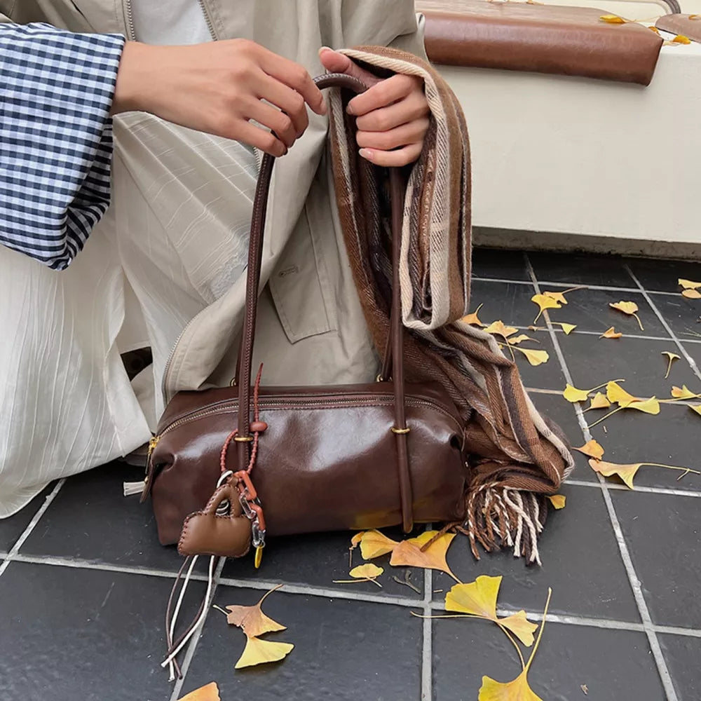 Brown pu leather shoulder bag with charm detail and scarf styling.