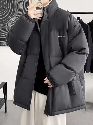 Black oversized quilted puffer jacket with funnel neck and embroidered detail.