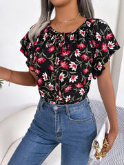 Floral ruffle sleeve tie-neck blouse in black with red and white flowers.