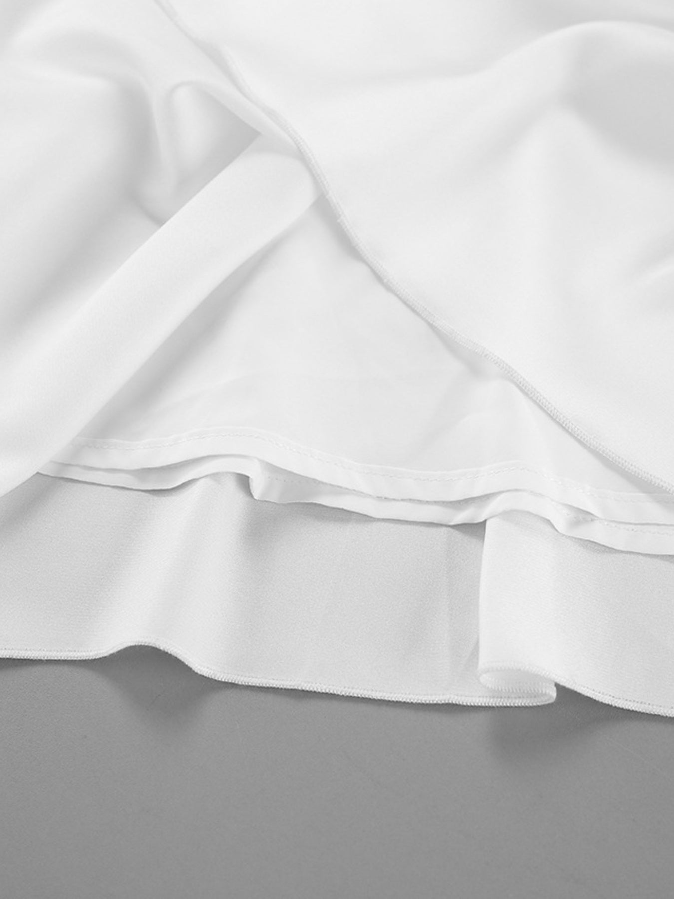 White high-waisted maxi skirt with pockets, showing layered fabric detail.