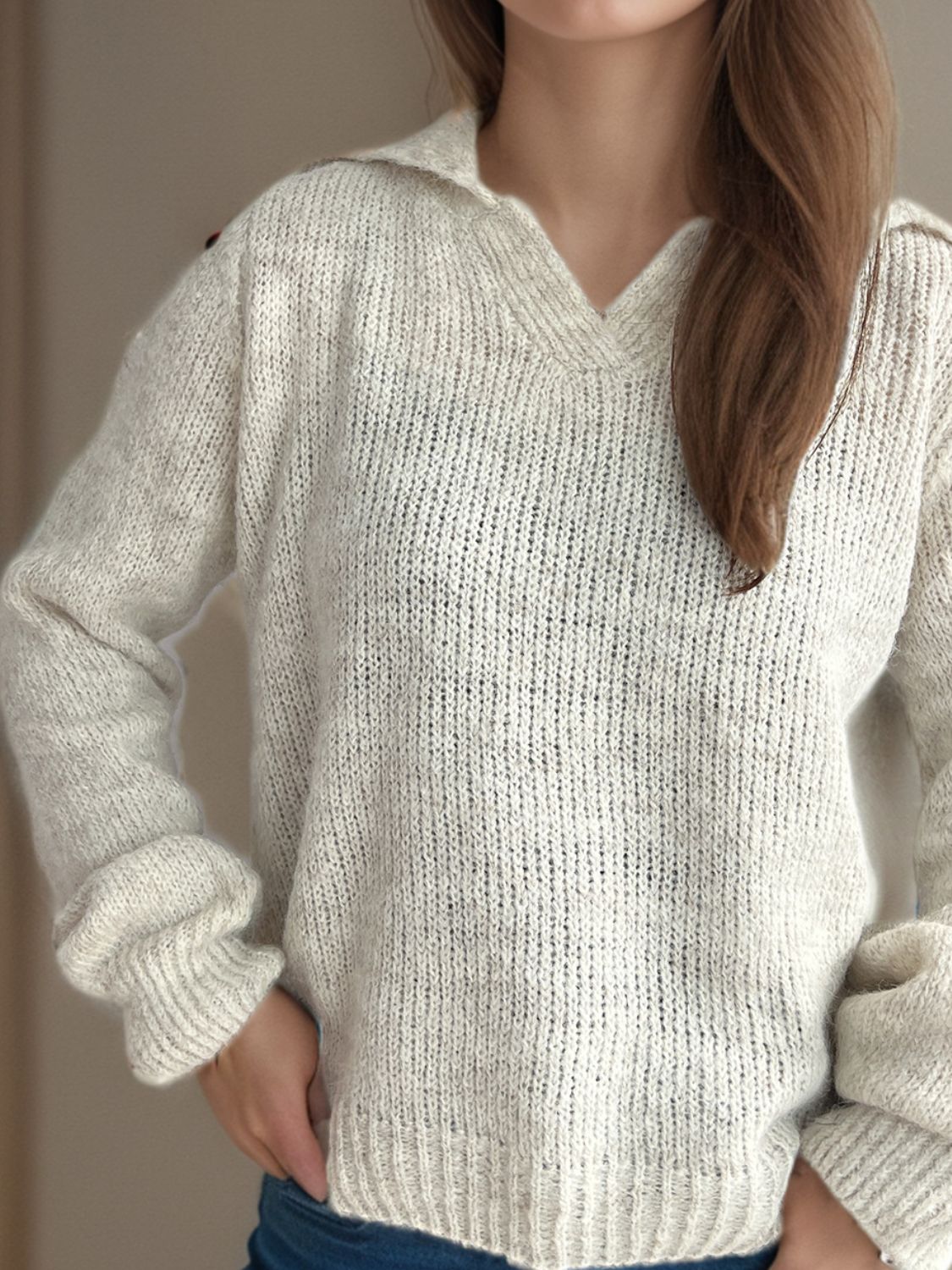 Textured knit polo sweater in beige with a V-neck and long sleeves.