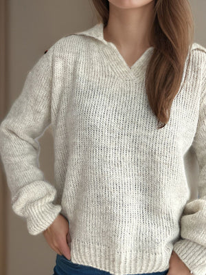Textured knit polo sweater in beige with a V-neck and long sleeves.
