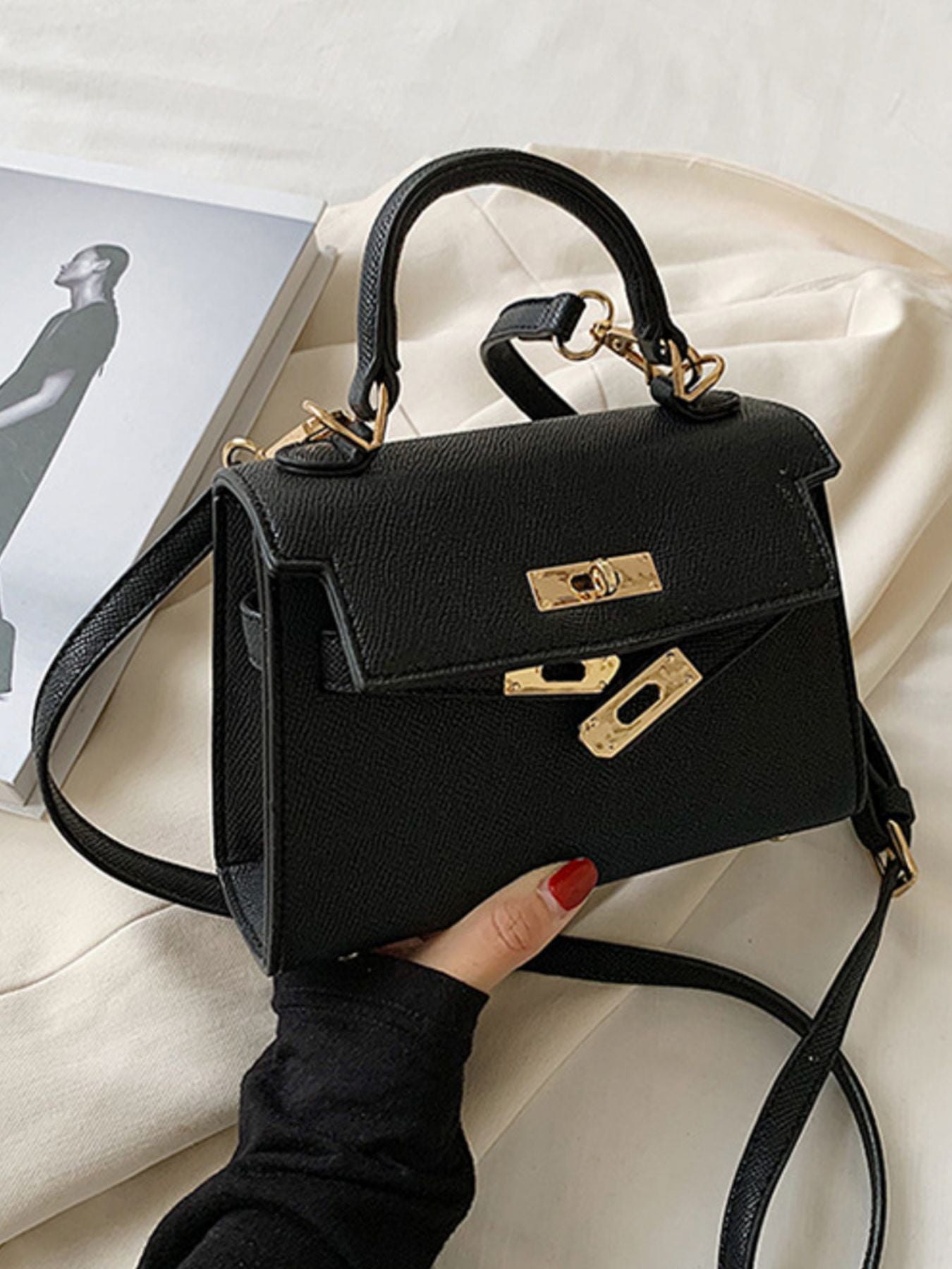 Black mini crossbody bag in textured pu leather with gold hardware and top handle.
