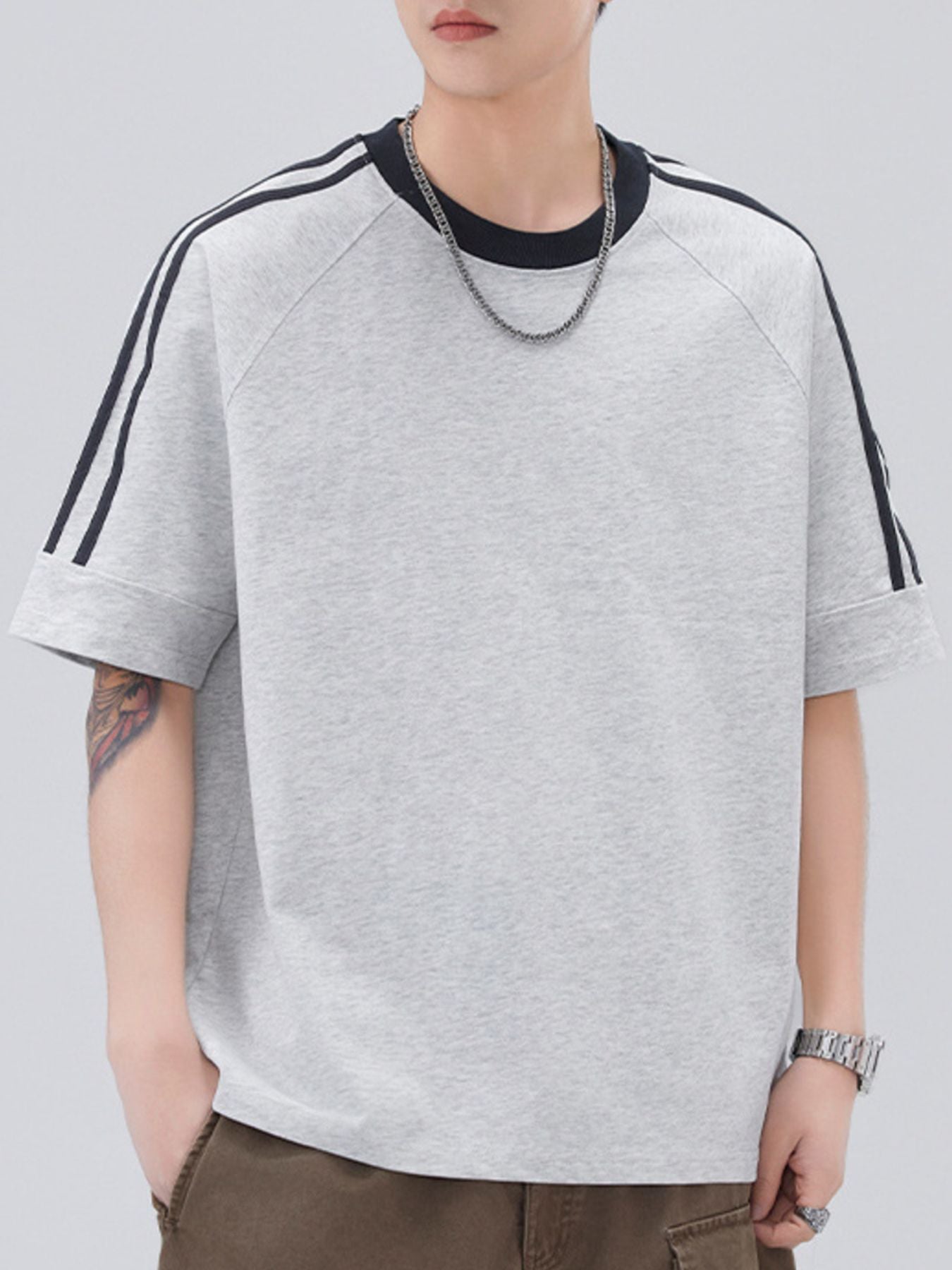 Light gray oversized t-shirt with contrast black stripes on sleeves and neckline.