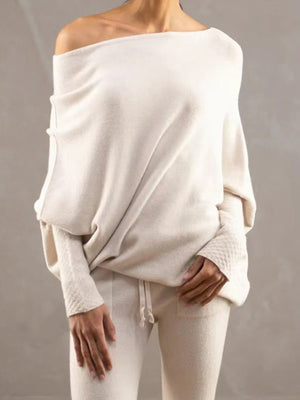 Cream off-shoulder drape knit sweater with textured cuffs and batwing sleeves.